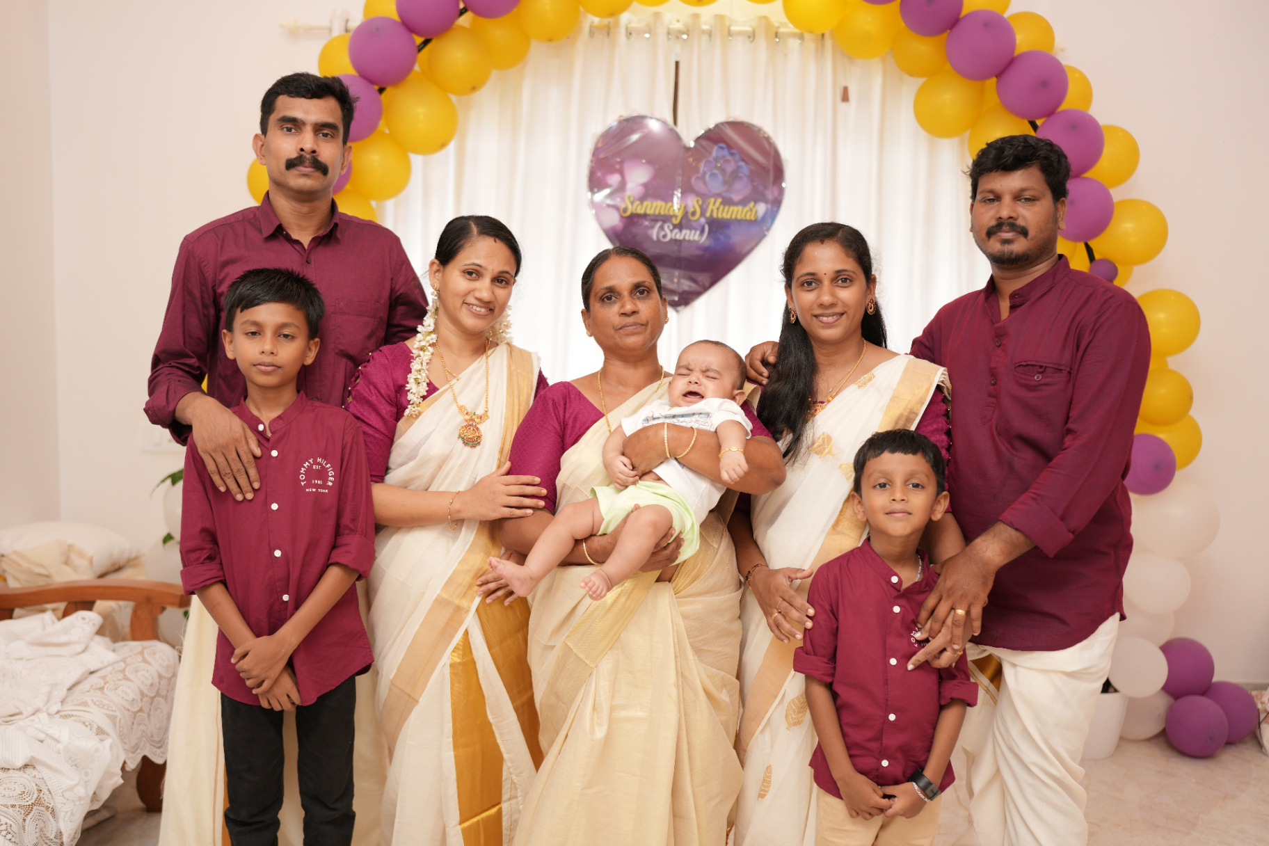 Family group portrait under the balloon arch