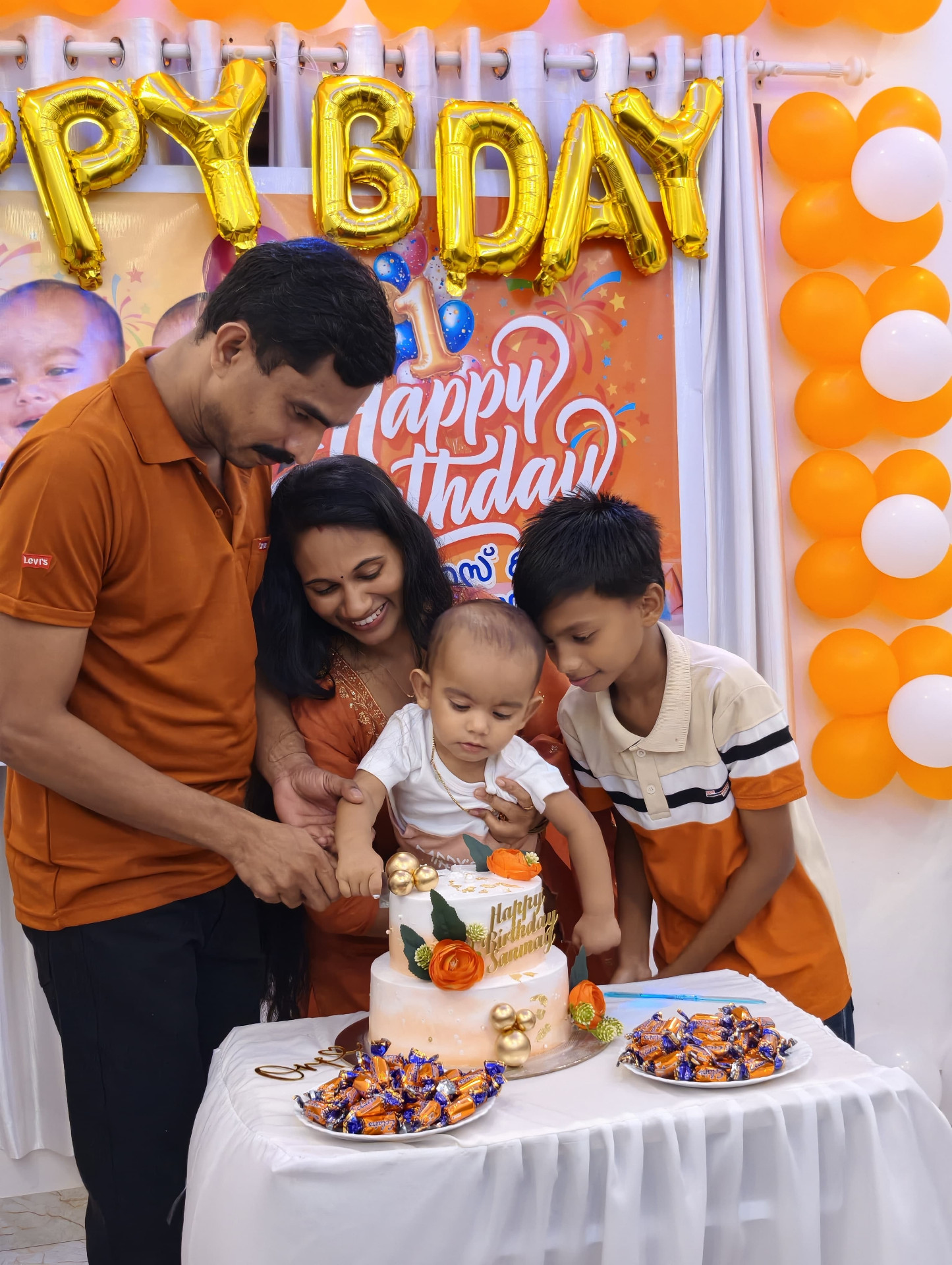 Close-up of Sanu cutting his first birthday cake with family