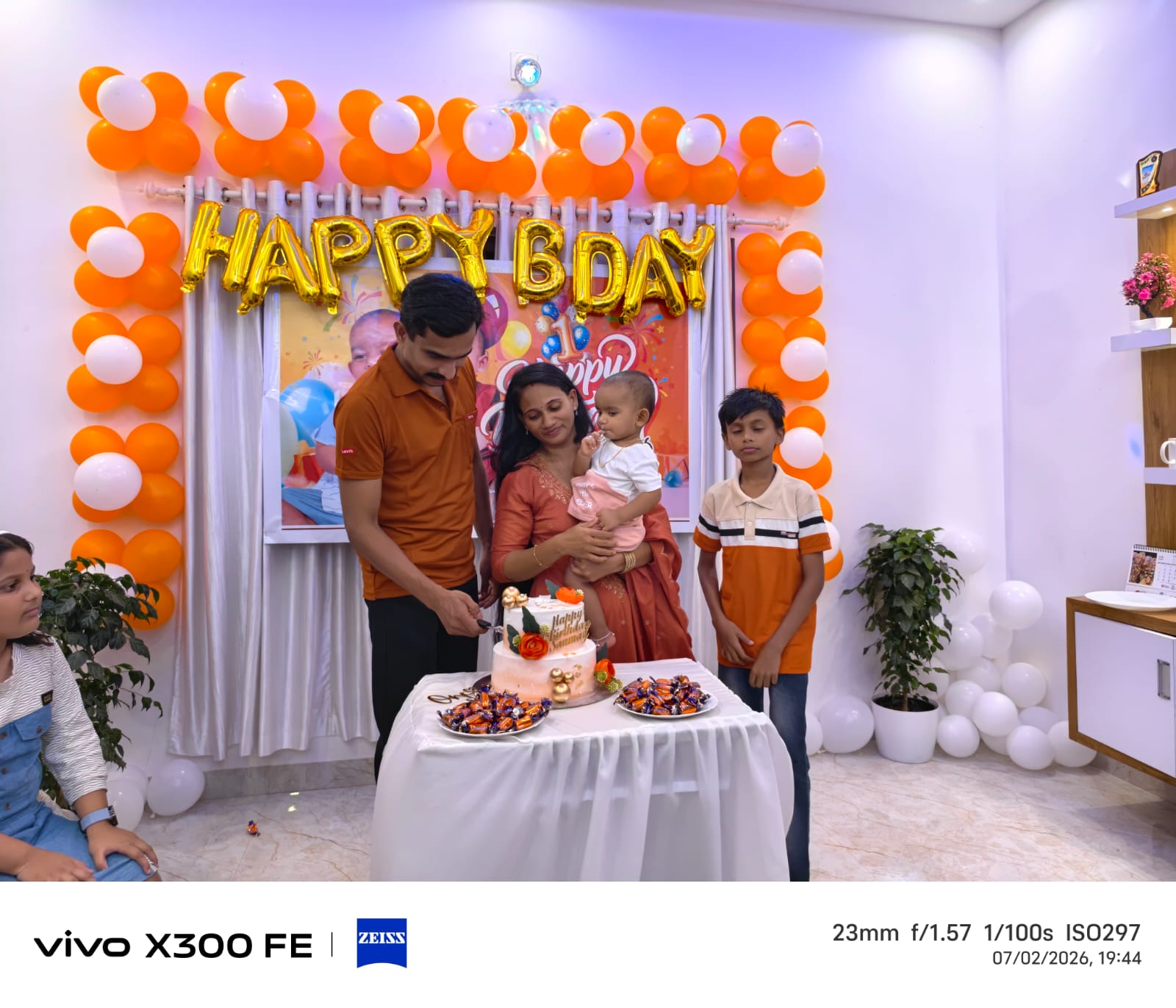 Family cutting the birthday cake together